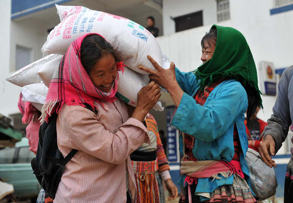 A woman carrying rice provided by the Red Cross Society in Guangxi in April 2010. The society gave 30 metric tons of rice to low-income villagers in Longlin county. Zhou Hua / Xinhua  Red Cross hopes to heal its reputation