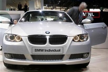 In this file photo journalists look at the BMW 335i on media day at the Paris Mondial de l'Automobile September 28, 2006.