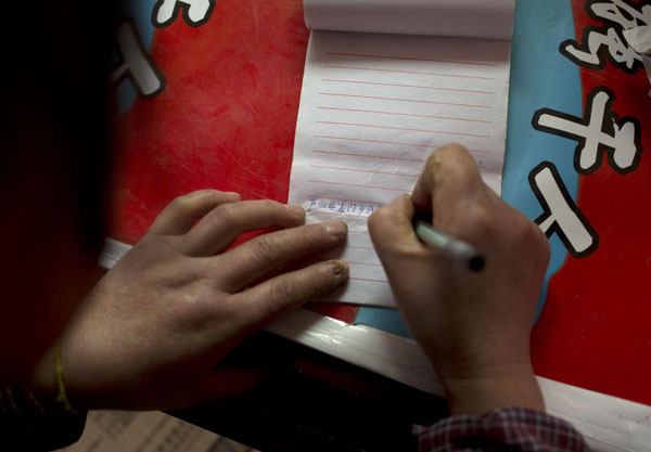 Gao Yunzhen helps her daughter wash her hair in Gucheng village of Lushan county in Southwest China's Sichuan province, April 24, 2013. Family seeks to keep memento of disaster