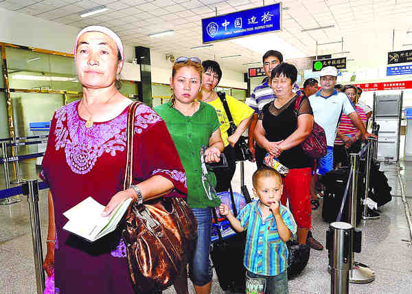People heading for Kazakhstan wait in line for customs clearance procedures at Horgos Port in the Xinjiang Uygur autonomous region in this file photo taken on July 20, 2009.  Horgos Port returns as major gateway