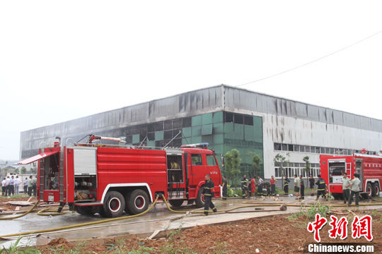 Two firefighting trucks stop outside a warehouse in an industrial park in Wuhan,capital of Central China's Hubei province July 12, 2011.[ 12 killed in warehouse fire in C China city