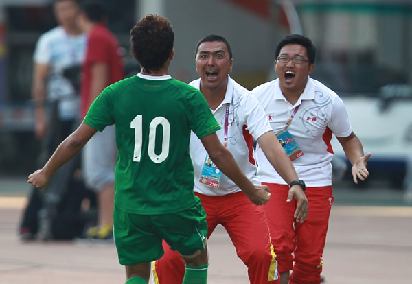 Xinjiang's head coach, center, reacts after the team player scores an equalizer against hosts Liaoning during their first-ever semifinal at the National Games, on Sept 8, 2013. Xinjiang scores on the national stage at last
