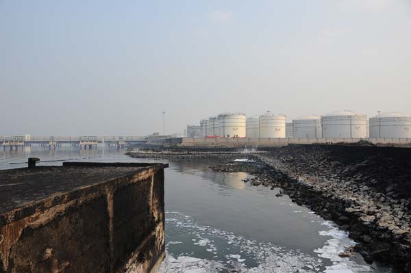 Oil spills after a pipeline blast in the East China port city of Qingdao, Shandong province, Nov 22, 2013. Barricades, boats deployed in pipeline spill