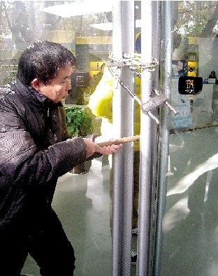 店員在玻璃門(mén)鎖三把鎖 小偷用長(zhǎng)棍挑走電腦(圖)