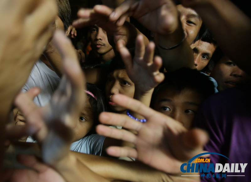 菲律賓洪水災(zāi)民爭搶救濟(jì)物品 “潭美”已致8人死亡(組圖)