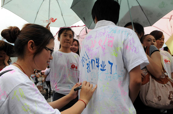 A graduate signs on a classmate's T-shirt during a graduation ceremony at China West Normal University in Nanchong city, Southwest China's Sichuan province, June 22, 2011. It's graduation time