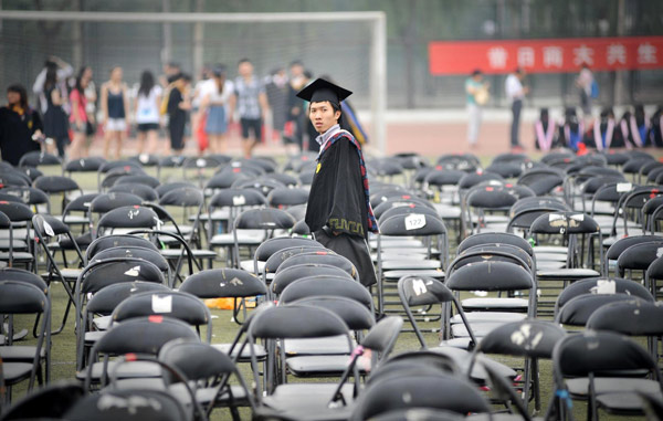 A graduate looks on after the graduation ceremony at Tianjin University of Commerce in Tianjin, June 22, 2011. It's graduation time
