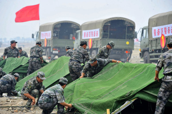 Paramilitary policemen set up tents during an emergency response drill in Tianjin, July 6, 2011. 6,000 take part in emergency response drills