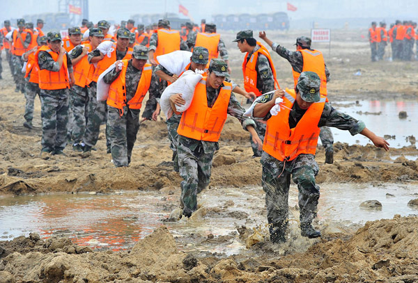 Paramilitary policemen march with sandbags during a simulated flood as part of an emergency response drill in Tianjin, July 6, 2011. 6,000 take part in emergency response drills