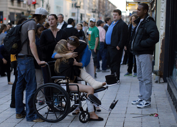 A Boston Marathon bombing survivor receives a hug next to the site of the first bomb explosion on Boylston Street in Boston, Massachusetts, April 24, 2013.  Boston bombs set off by toy remote