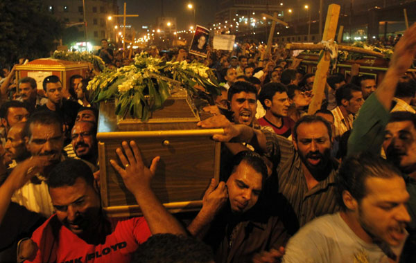 Egyptian Coptic Christians carry coffins as they make their way to Abassaiya Cathedral during a mass funeral for victims of sectarian clashes with soldiers and riot police, after a protest about an attack on a church in southern Egypt, in Cairo October 10, 2011.  Egypt's finance minister resigns after clash