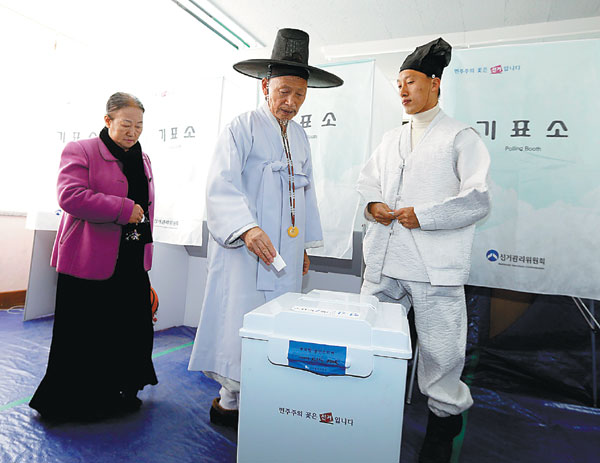 Yoo Bok-yeob (C), 72, a village schoolmaster, casts his ballot with his family members in the Republic of Korea's presidential election at a polling station in Nonsan, about 190km south of Seoul, on Wednesday. ROK elects first female president