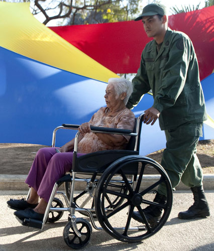 A Venezuelan soldier helps a woman in a wheelchair to go to vote at a polling station in Caracas on Sunday. Venezuelans headed to the polls to elect Hugo Chavez's successor. Raul Arboleda / Agence France-Presse Venezuelans to decide direction of the nation