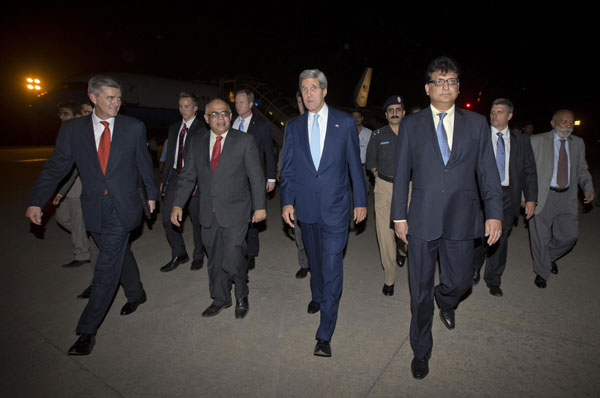 U.S. Secretary of State John Kerry (C) walks with U.S. Ambassador to Pakistan Richard Olson (L) and unidentified Pakistani officials upon his arrival in Islamabad July 31, 2013. Kerry in Pakistan on unannounced visit
