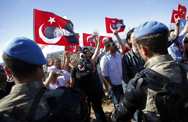 Protesters are blocked by Turkish soldiers as they try to march to a courthouse in Silivri, where a hearing for people charged with attempting to overthrow Prime Minister Tayyip Erdogan's Islamist-rooted government is due to take place August 5, 2013. Turkish court will pass judgment on Monday on nearly 300 defendants accused of plotting to topple the government in a battleground case in the decade-long conflict between Prime Minister Tayyip Erdogan and Turkey's secularist establishment. Security forces set up barricades around the courthouse in the Silivri jail complex, west of Istanbul, to tighten security after the defendants' supporters vowed to hold a demonstration against the five-year trial that has exposed deep divisions in Turkish society.  Turkish police clash with protesters over coup trial