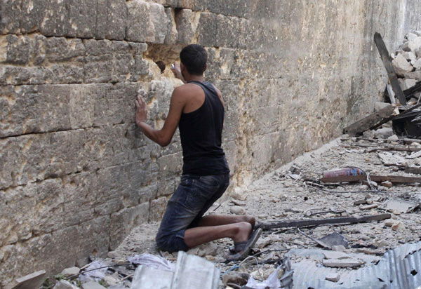 A Free Syrian Army fighter prepares a locally made bomb in a wall, to make a hole for snipers, in old Aleppo, August 25, 2013. Syria lets UN inspect gas attack site