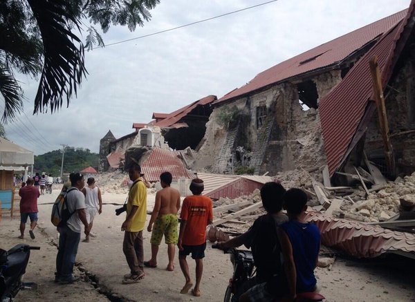People walk past the damaged Church of San Pedro in the town Loboc, Bohol, after a major 7.2 magnitude earthquake struck the region, on Oct 15, 2013.  20 killed in strong Philippine quake